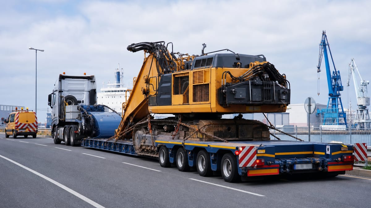 Trasporto eccezionale con semirimorchio ribassato e macchinario industriale in area portuale